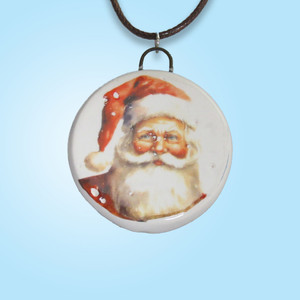 A Round Santa with Snowflakes Handmade Ceramic Necklace. On a black corded necklace. With a light blue background. A round santa with snowflakes handmade ceramic necklace. On a black cord necklace. With a light blue background. A Round Santa with Snowflakes Handmade Ceramic Necklace. On a black corded necklace. With a light blue background. A round santa with snowflakes handmade ceramic necklace. On a black cord necklace. With a light blue background.