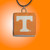 A TN Vols Orange with White Power T square ceramic necklace. On an orange background.