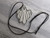 A handmade ceramic ghost statement pendant necklace. On a black cord necklace. In a laying position. With a gray marble look background. A handmade ceramic ghost statement pendant necklace. On a black cord necklace. In a laying position. With a gray marble look background.