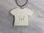 The back view of a handmade fun Christmas Tshirt necklace. With the words "Fueled by Coffee and Christmas Music". With the letters PFM imprinted in the back of the pendant. The back view of a handmade fun Christmas Tshirt necklace. With the words "Fueled by Coffee and Christmas Music". With the letters PFM imprinted in the back of the pendant.