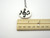 A handmade ceramic round pendant music notes in white with black music music notes necklace. On a silver chain necklace.  With ruler. Measuring approximately 1 inch wide.
