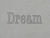 A clay imprint of the word Dream from an inspirational "Dream" clay pottery mug stamp for slab handbuild pottery.
