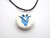 A handmade white with a blue tulip ceramic pendant necklace. On a black cord necklace.