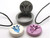 An abstract tulip clay pendant stamp and cutter. Shown with two finished necklaces; one white with a teal flower and the other solid purple. An abstract tulip clay pendant stamp and cutter. Shown with two finished necklaces, one white with teal flower and the other solid purple.