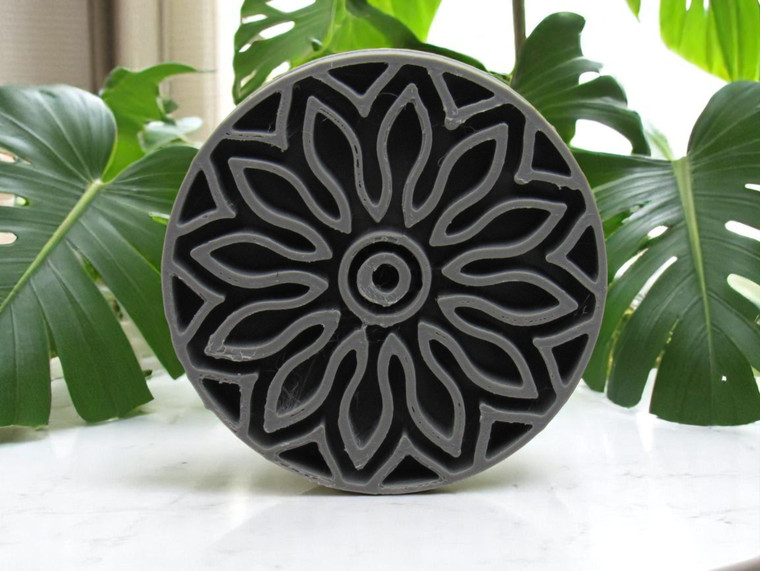 A mandala accent (Design 3) clay pottery texture stamp. With green plants on a marble look background.