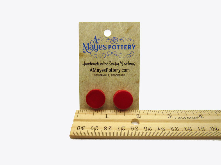 A set of handmade ceramic red medium circles post earrings. On an A Mayes Pottery card. With ruler.