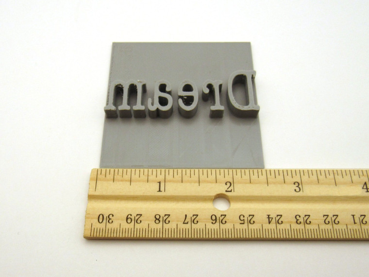 An inspirational "Dream" clay pottery mug stamp for slab handbuild pottery. With ruler. Measuring approximately 2.5 inches wide.
