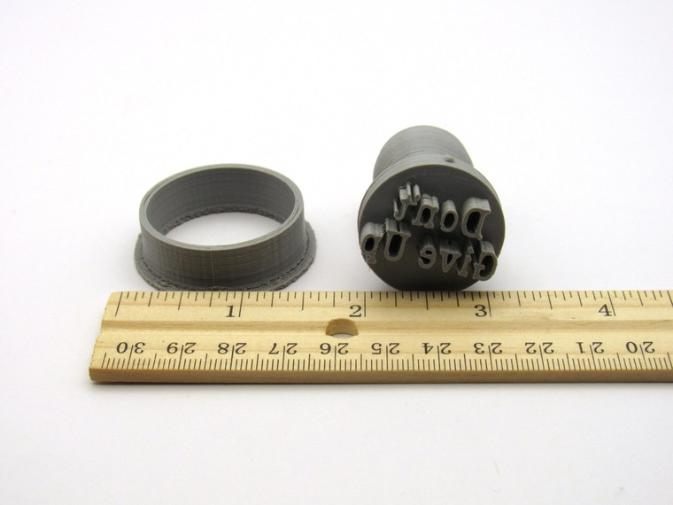 A "Don't Give Up" Round Pendant Clay Stamp with Cutter. With ruler. Measuring approximately 1 inch wide.