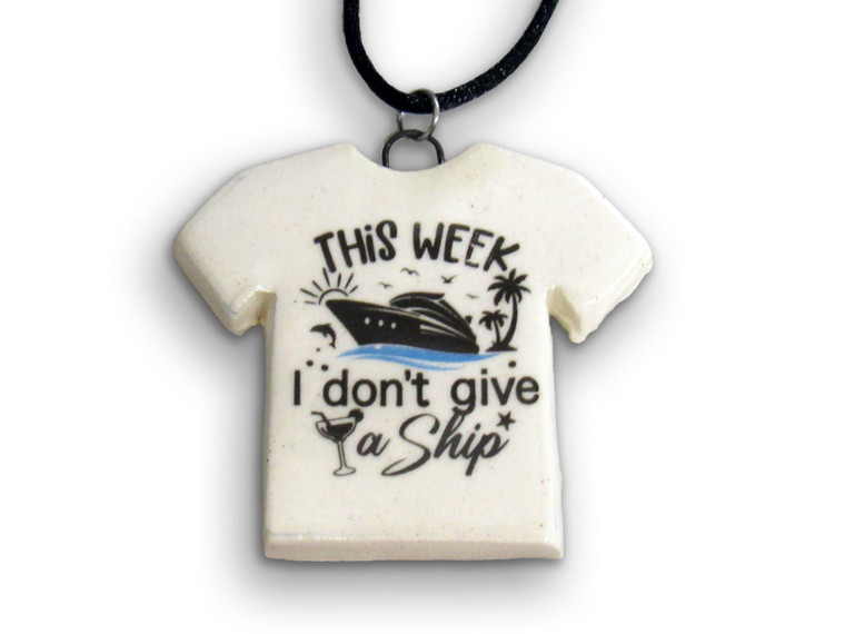 A handmade ceramic Tshirt necklace with the words "This week I don't Give a Ship. On a black cord necklace.