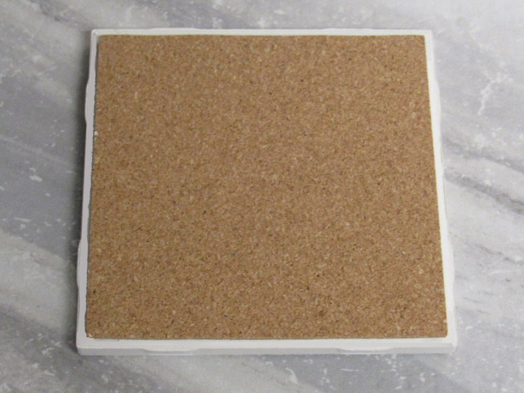 The back view of A UT Vols Orange Power T Ceramic Coaster Hot Pad Trivet. Showing the cork side. With a gray marble look background.