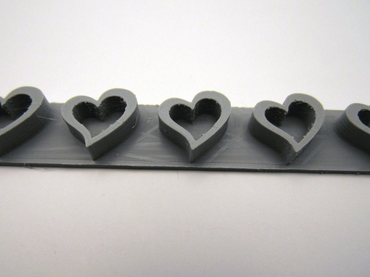 A slanted open heart border clay stamp for handbuild pottery.