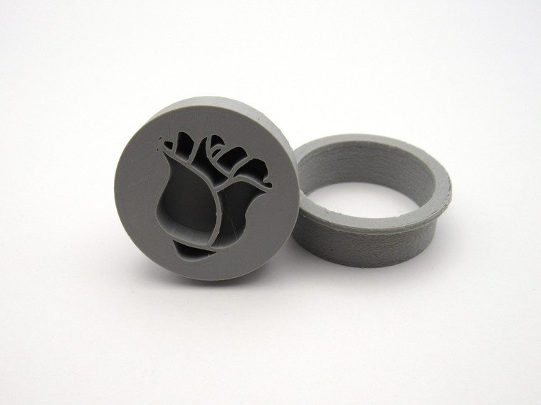 An inverted rosebud flower pendant clay stamp with round cutter. Shown with stamp tilted next to the cutter.