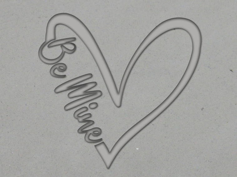 A clay imprint of a Valentine's Day Heart with the words "Be Mine" written on left side of the heart. A clay imprint of a Valentine's Day heart with the words "Be Mine" written on left side of the heart.