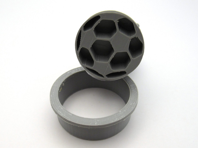 A Round Sports Pendant Soccer Ball Clay pottery Stamp with cutter. Shown with stamp tilted on top of cutter. A round sports pendant soccer ball clay pottery stamp with cutter. Shown with stamp tilted on top of cutter.