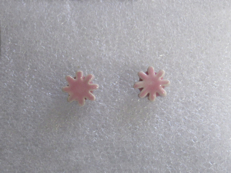 A set of Small pink flower burst ceramic clay pottery stud post earring jewelry on plain background. A set of small pink flower burst ceramic clay pottery stud post earring jewelry on plain background.