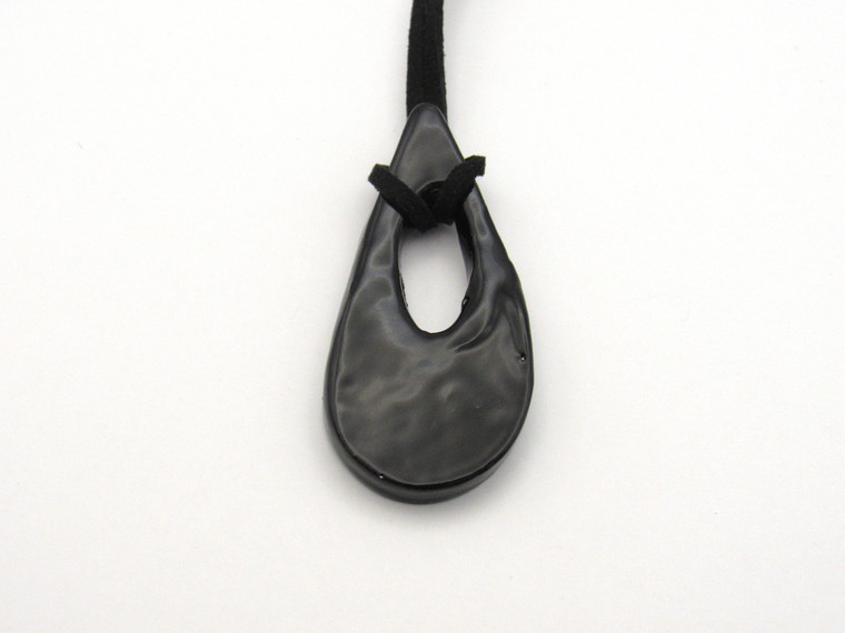 A black Handcrafted Teardrop Shaped Ceramic Pendant Necklace. On a black corded necklace. A black handcrafted teardrop shaped ceramic pendant necklace. On a black cord necklace.