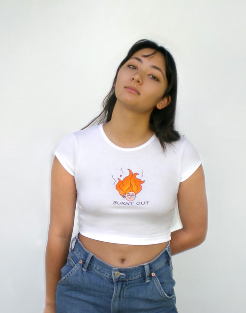 White cotton baby rib cap sleeve cropped tee. Screen printed fire head design. Reads "Burnt Out."