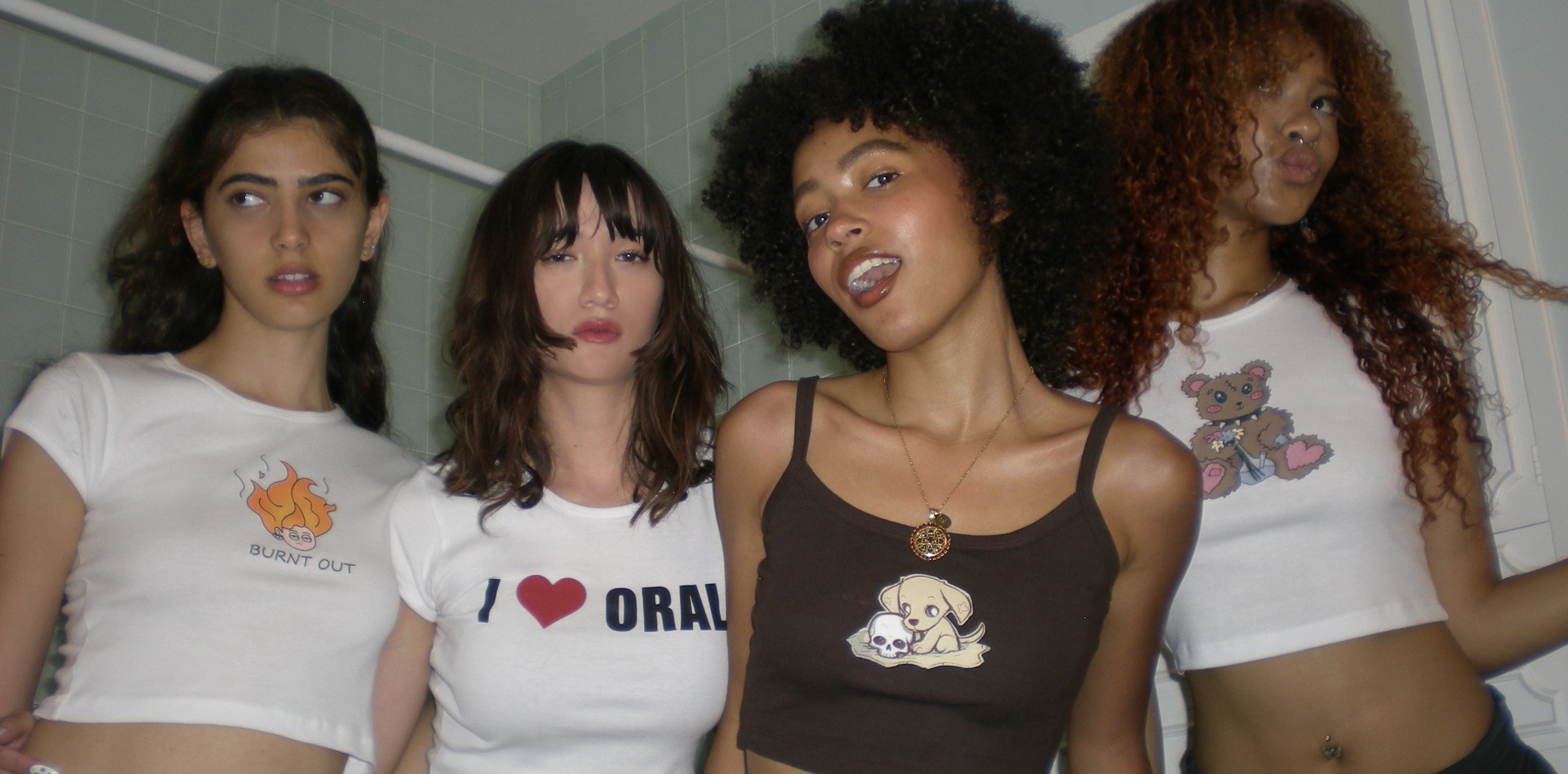 four girls wearing cotton cropped tops with screen printed designs.