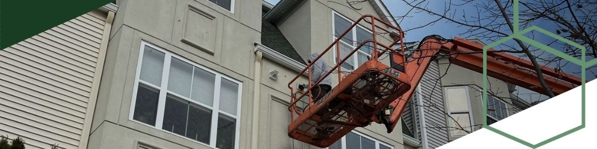 on cherry picker cleaning dryer vent on upper floor of complex