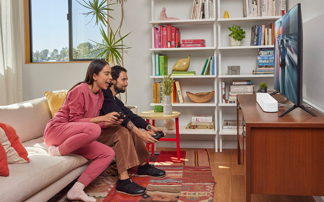 Sonos Beam Gen 2 soundbar in White on a stand beneath a TV in a living room