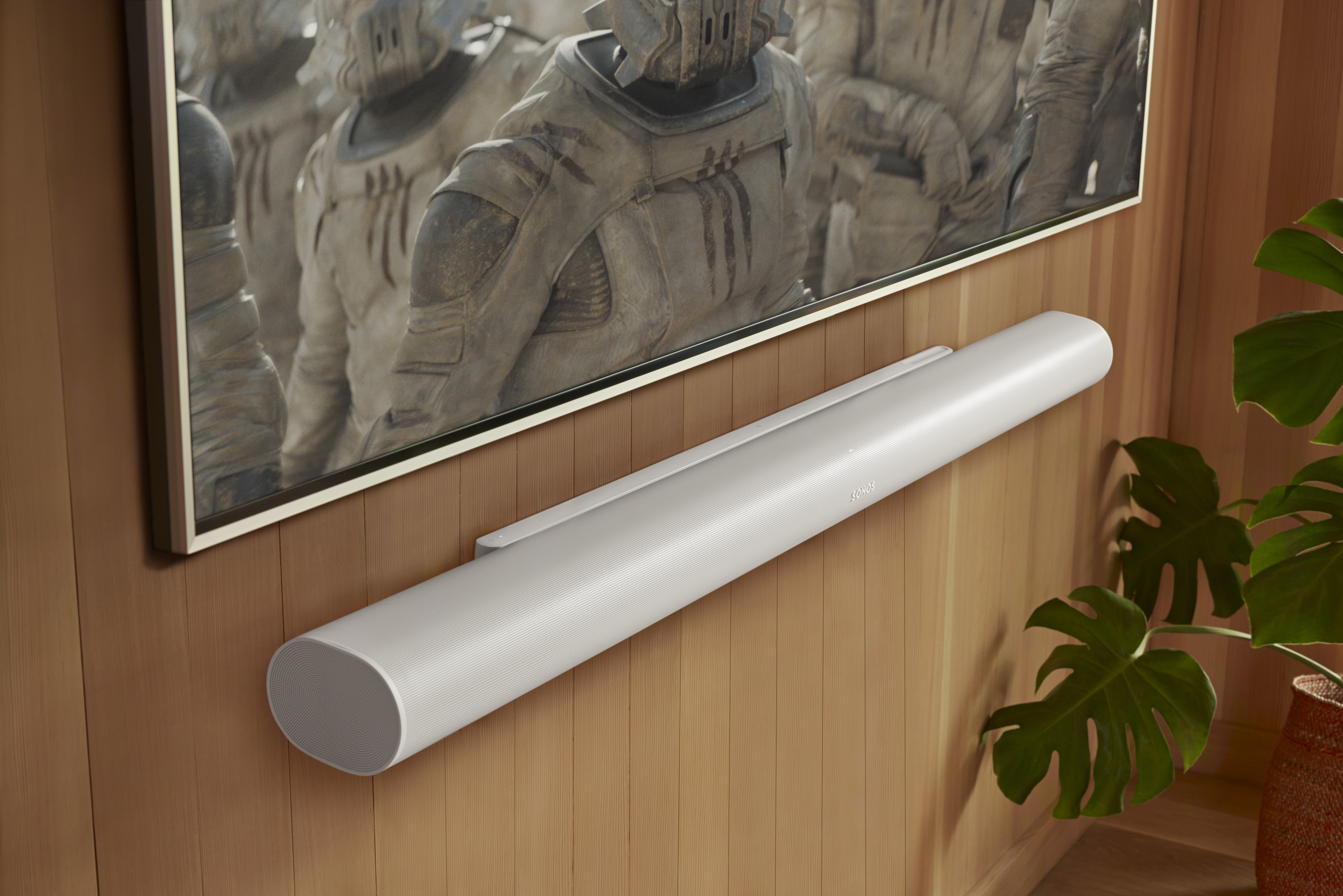Sonos Arc Ultra shown in white, wall mounted with a TV