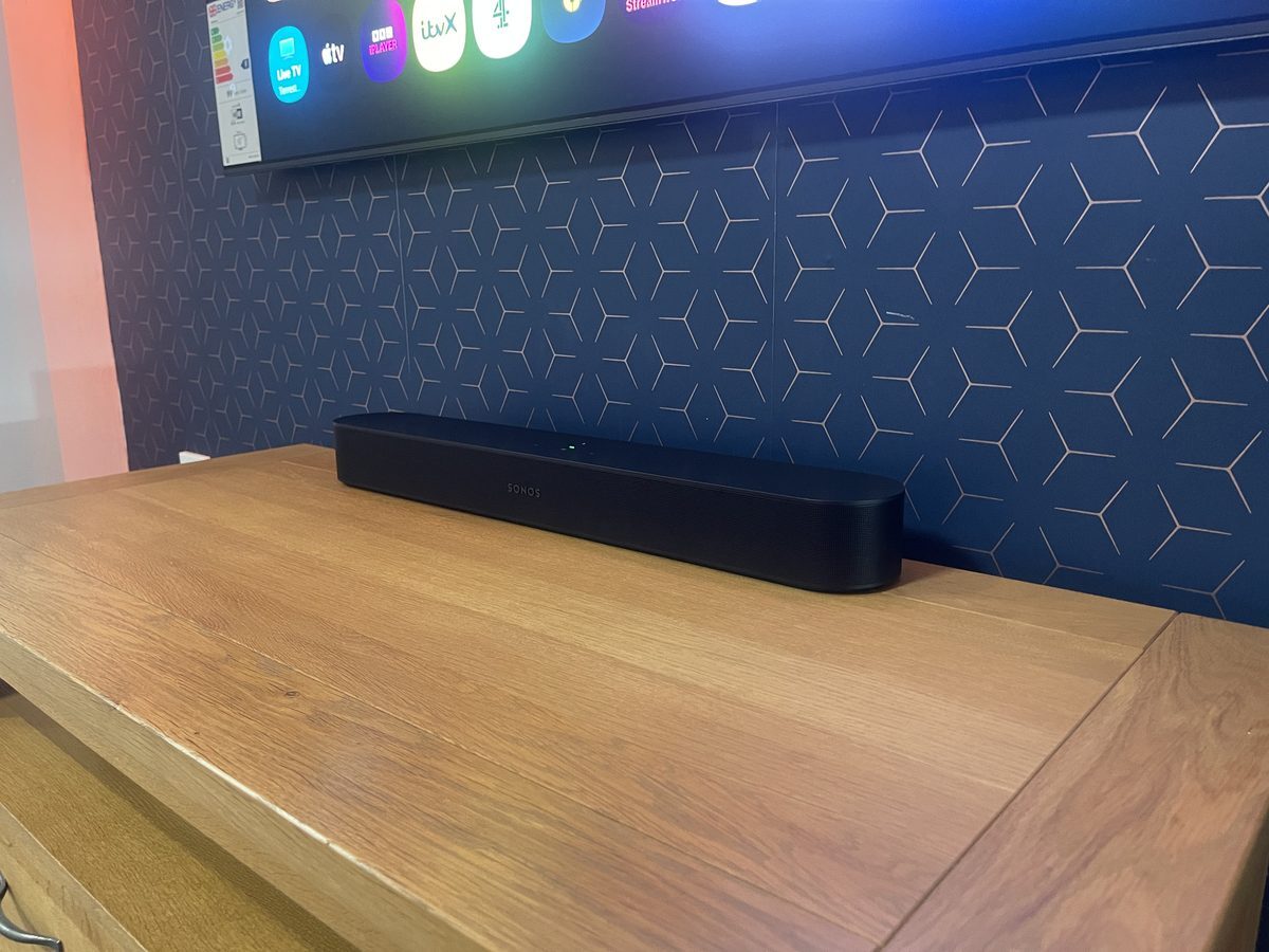Sonos Beam Gen 2 soundbar on an oak TV cabinet beneath a wall-mounted TV in the Jennings showroom, Fleet