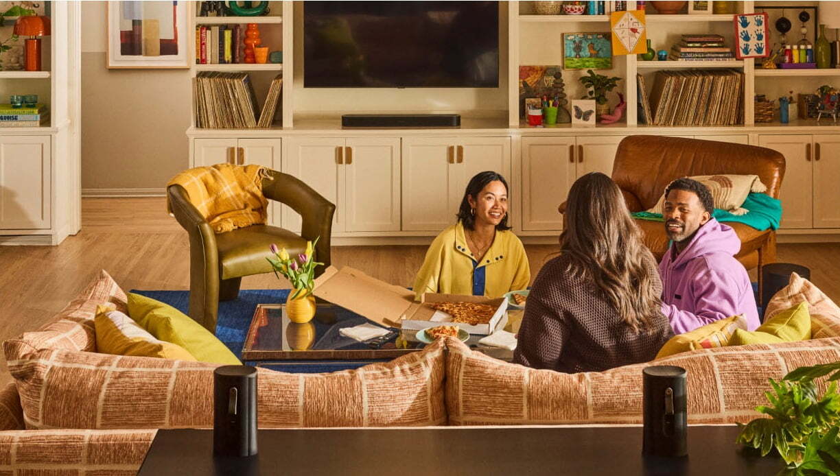 Friends relaxing in a living room with Sonos Beam Ultra soundbar