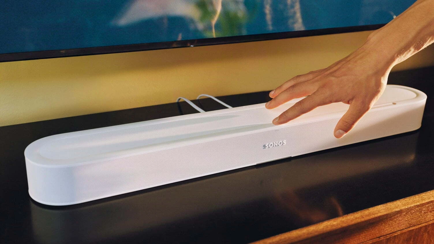 White Sonos Beam Ultra soundbar on a TV unit in front of a TV