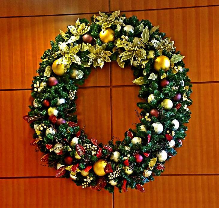 wreath decorated with flowers and ornaments hanging on a wall