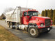 1998 350 hp R-Model Mack Tri Axle Dump Truck, features a 15.5-foot aluminum dump bed.