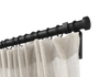 Black non-telescoping, steel, custom curtain rod set with Highland Forge's disc finial and a beige curtain.
