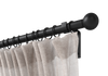 Black non-telescoping, steel, custom curtain rod set with Highland Forge's ball finial and a beige curtain.