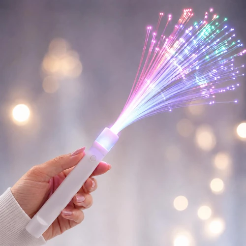 hand holding a glowing fiber optic light wand with colorful illuminated fibers spreading out in a fan shape