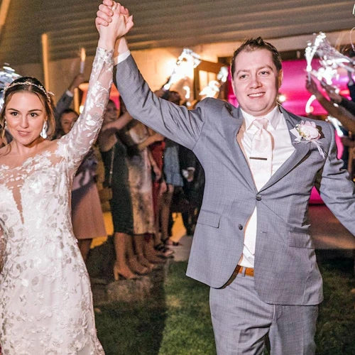 couple dancing at a wedding reception holding fiber optic LED wands illuminated in vibrant colors