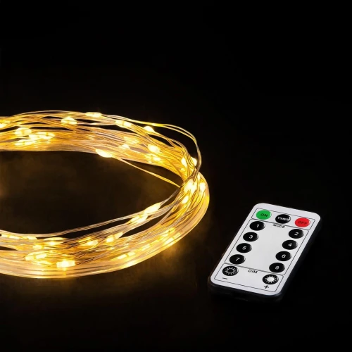 Warm white fairy wire lights glowing on a dark background with remote control
