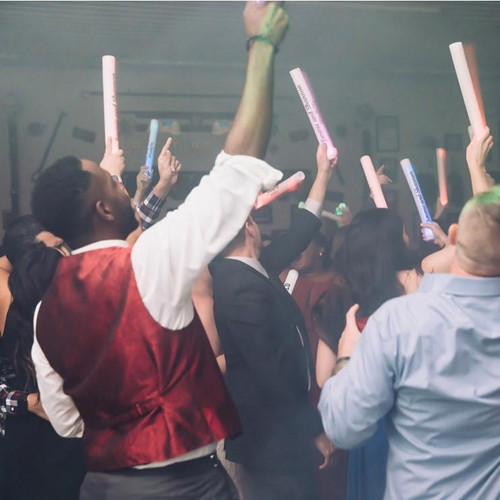 Customized 7 Mode LED Foam Glow Sticks | Flashing Foam Sticks - Extreme Glow, people dancing and celebrating with illuminated foam glow sticks at a party or music event.