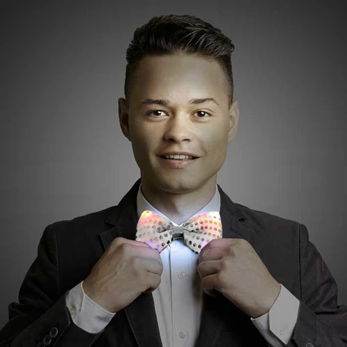 LED Sequin Bowtie, a man wearing a stylish black suit adjusting a colorful LED sequin bowtie.