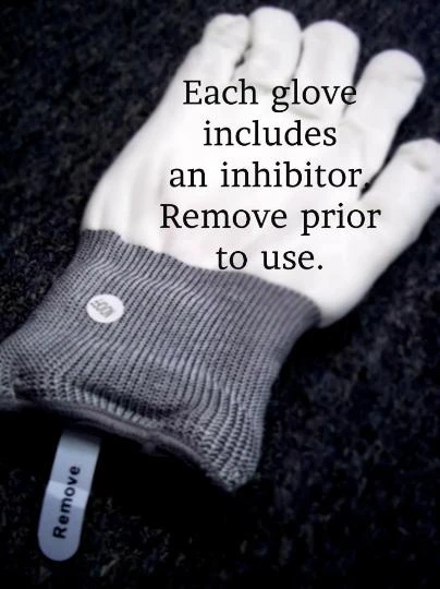XO Multi Glove, close-up image of a white glove with a grey wristband and a label that reads 'Remove', with text indicating each glove includes an inhibitor and to remove prior to use.