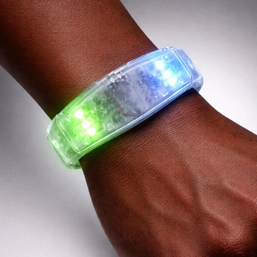 Multicolored Click Bracelet, a transparent LED light-up bracelet with green and blue lights on a person's wrist.