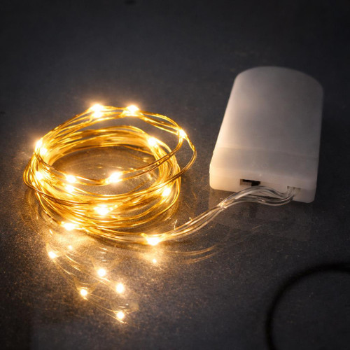 39 Inch Fairy Wire Various Color Options LEDs, LED fairy light cord with white battery pack and replaceable coin cell batteries, illuminated and coiled on dark surface.