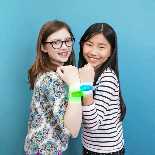 16 Mode Multicolor LED Bracelet, two girls smiling and showcasing glowing multicolor LED bracelets on their wrists against a blue background.