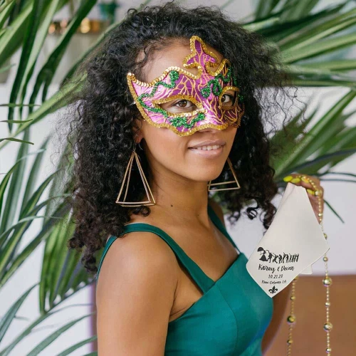 vibrant Mardi Gras mask with green, purple, and gold embellishments worn by a woman