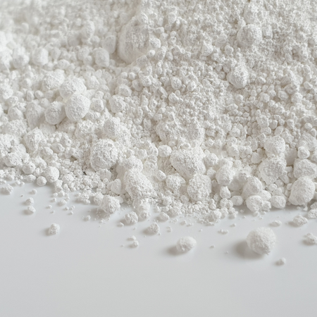 A close-up of white granular Titanium Dioxide powder spread out on a flat surface A close-up of white granular Titanium Dioxide powder spread out on a flat surface