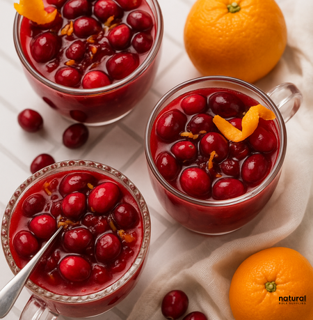 Top view of glass cups filled with cranberry-orange fruit compote, surrounded by fresh clementines – vibrant, festive visual for Cran-Merry Orange scent.