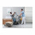 A caregiver assists a patient using an Invacare ISA XPLUS Stand-Up Electric Patient Lift in a modern, well-lit room with a bed and seating area.
