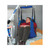 A patient is suspended in a blue and green lifting sling, with a caregiver operating a 600 lb capacity lift in a home-like environment.