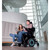 Invacare TDX SP2 HD Power Wheelchair with center wheel drive system, shown in a spacious indoor setting; features teal-accented central drive wheels for enhanced maneuverability and tight turning radius, with front and rear casters for stability and smooth navigation.