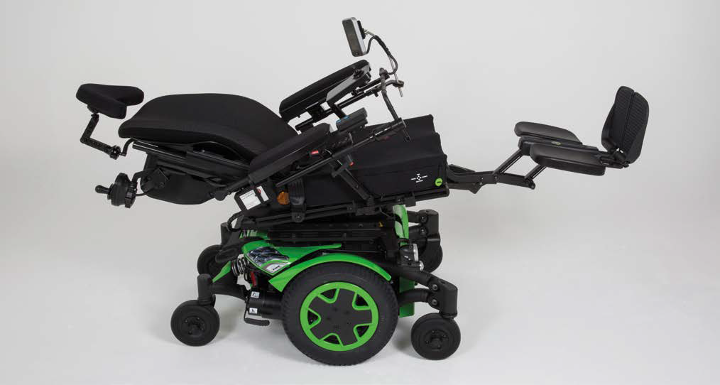 A modern TDXSP2 electric wheelchair with a black seat and green wheels is shown in a reclined position. The wheelchair has various adjustable components, including armrests, footrests, and a headrest. The design appears to be ergonomic and customizable for user comfort.