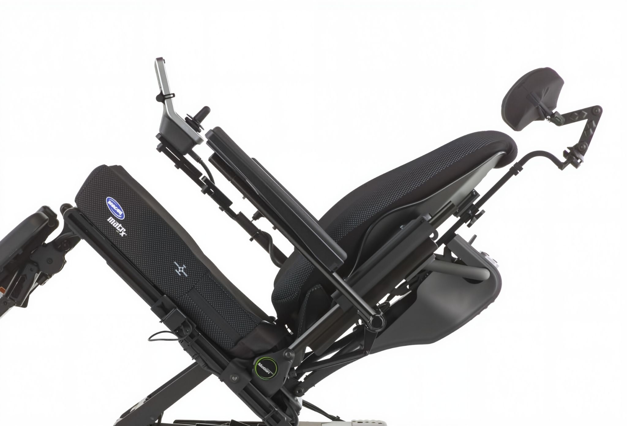 Ultra Low Maxx positioning system attached to an Invacare wheelchair, shown from the side with its adjustable backrest, cushioned headrest, and ergonomic support features designed for customized comfort and posture alignment.