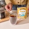 Putting Four sigmatic vanilla creamer in coffee. 